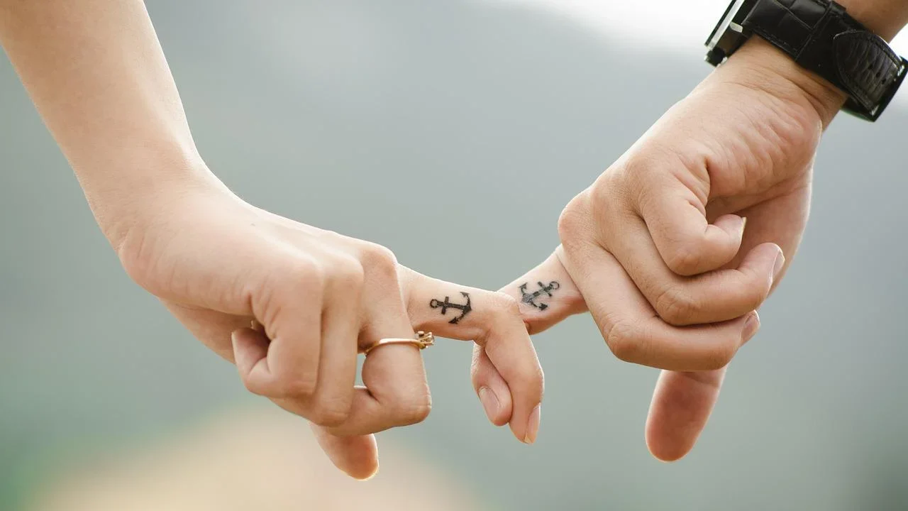 a couple linking hands wearing a watch anniversary watch engraving ideas